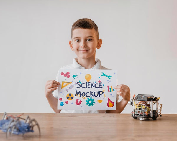 Free Kid Holding A Card Mock-Up While Learning Science Psd