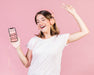Free Happy Young Woman With Headphones Holding A Cellphone Mock-Up Psd
