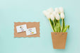 Free Top View Of White Tulips And Cards Psd