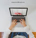 Free Woman Typing On Laptop Sitting At White Table Psd