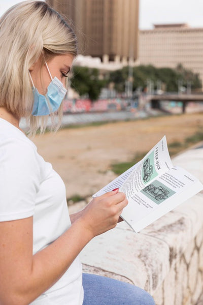 Free Woman With Mask Reading Book On Street Psd