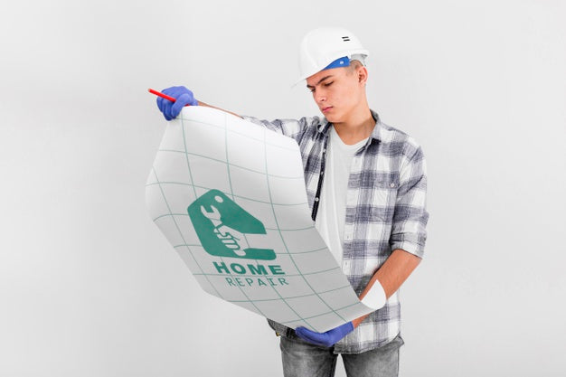 Free Young Handyman Looking On A Blueprint Psd